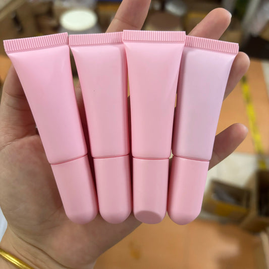 Empty matte plastic squeeze lip balm tubes in white and pink