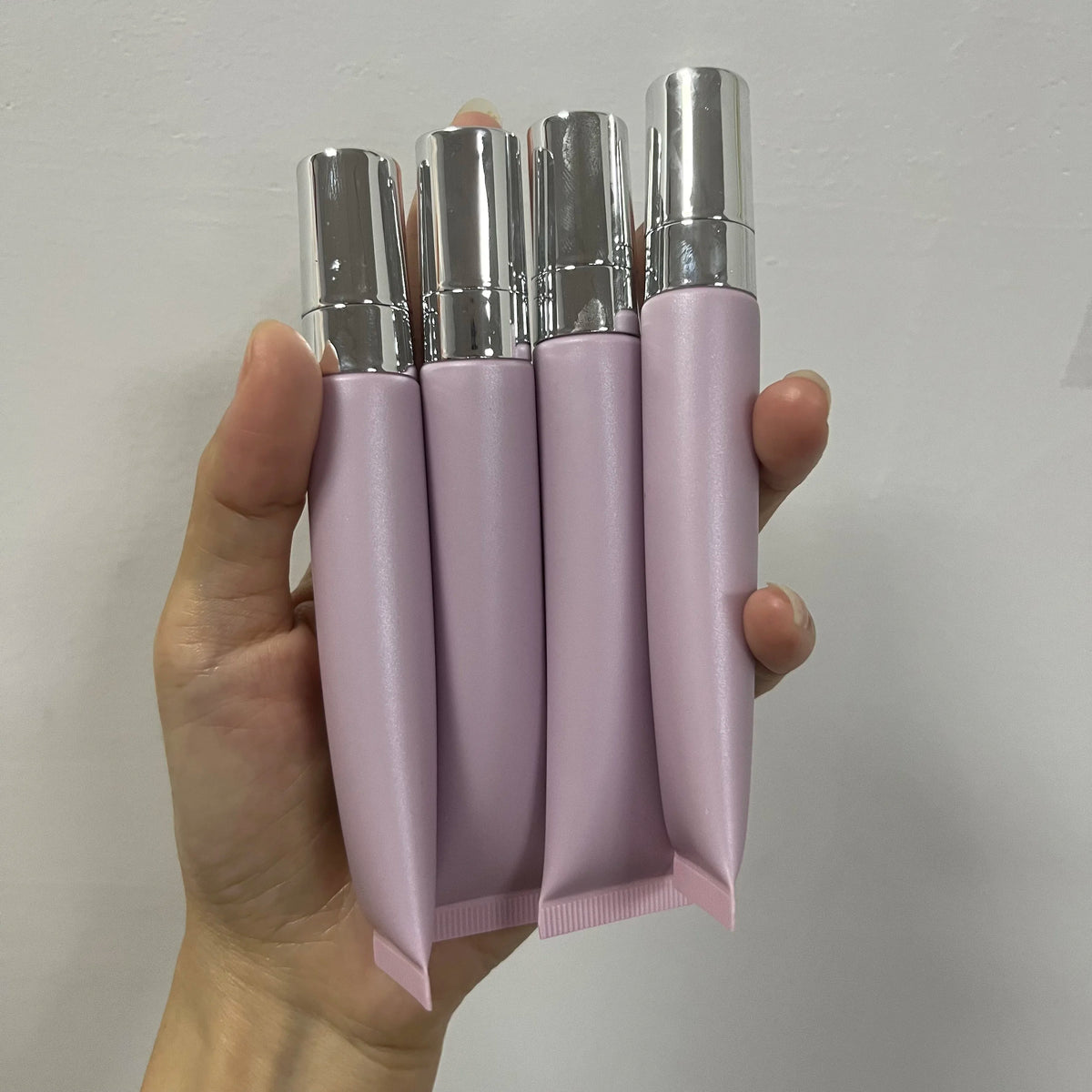 Empty plastic lip gloss squeeze tube with metal applicator